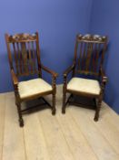 Pair of high backed hall arm chairs, with cream upholstered seats