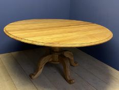 Good Quality light oak circular dining table, moulded edging with dropped flaps on a heavy turned