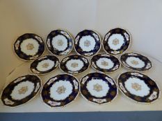 Set of 12 Coalport cabinet plates with floral decoration to a dark blue and gilt ground