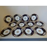 Set of 12 Coalport cabinet plates with floral decoration to a dark blue and gilt ground