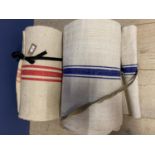 Two sizeable rolls of natural hessian fabric with blue and red stripes. Red 21.4 metres Blue 18.4