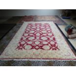 Modern handmade Ziegler carpet, plum central panel decorated with large stylised flowers with a wide