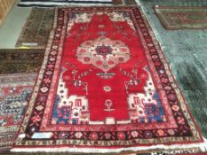 Modern bright red ground woollen rug with central medallion and multi border 260 x 150