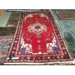 Modern bright red ground woollen rug with central medallion and multi border 260 x 150