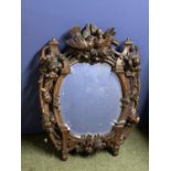 Good Oval bevelled wall mirror within a heavily carved open Italian walnut frame, depicting fruit
