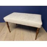 A rectangular seat upholstered stool in cream damask fabric on turned mahogany legs. 89cmW x 50 x