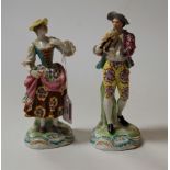 A pair of continental porcelain figures in the 18th century style, each heightened in gilt and