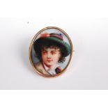 A continental painted porcelain brooch depicting a young boy, in yellow metal mount, unmarked but