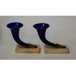 A pair of blue glass cornucopia vases, on marble plinths, h.17.5cm