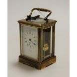 An early 20th century lacquered brass cased carriage clock, having an enamelled dial with Roman