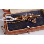 An Edwardian 9ct gold ruby and seed pearl set safety pin bar brooch, with safety chain, 2.7g,