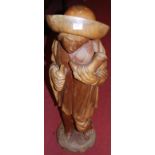 A Continental carved hardwood figure of a standing man, holding a bottle and cornucopia, height