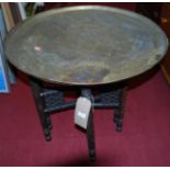 An early 20th century circular engraved brass topped folding Benares table, dia. 69cm