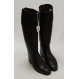 A pair of black leather calf length riding boots