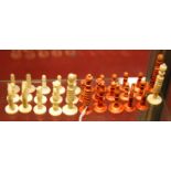 A set of 19th century turned bone chess pieces, one side in natural, the other side red stained,