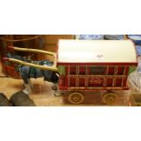 A painted model of a gypsy caravan with ceramic shire horse