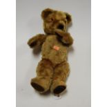 A blond mohair teddy-bear, having centre stitched body with moving limbs and glass eyes, h.37cm