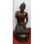 A 20th century Asian carved teak? figure of a kneeling man, 67cm high