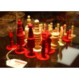 A 19th century turned ivory part chess set, one side natural and the other side stained red, king