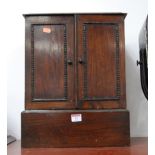 A 1930s oak table cabinet, enclosed by a pair of moulded doors, on large plinth base, w.34cm