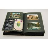 An early 20th century cloth bound and gilt tooled postcard album, containing a large collection of