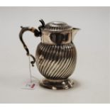An 18th century white metal water jug, of wrythen form, the hinged cover with raised thumbpiece,