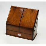 A Victorian walnut stationery cabinet, the hinged sloping front opening to reveal a fitted