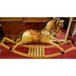 A contemporary carved sycamore and elm rocking horse, having horse hair mane and tail, with tan