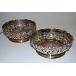 A pair of Victorian Old Sheffield Plate bottle coasters, of squat circular form, with pierced