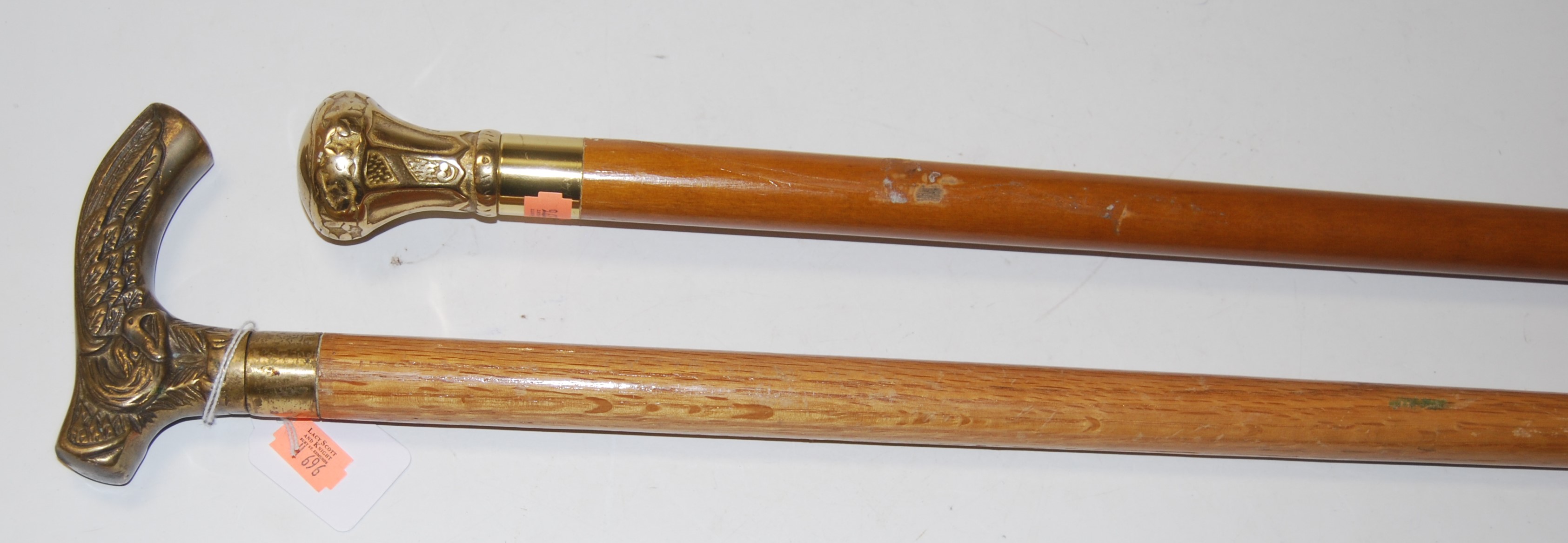 A modern walking cane, having embossed brass handle; together with another similar (2)