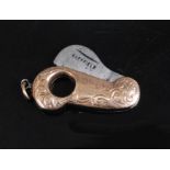 An early 20th century 9ct gold pocket cigar cutter of shaped form with engraved decoration having
