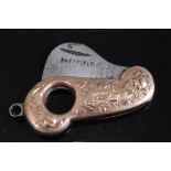 A circa 1900 9ct gold pocket cigar cutter of shaped form having foliate engraved decoration and