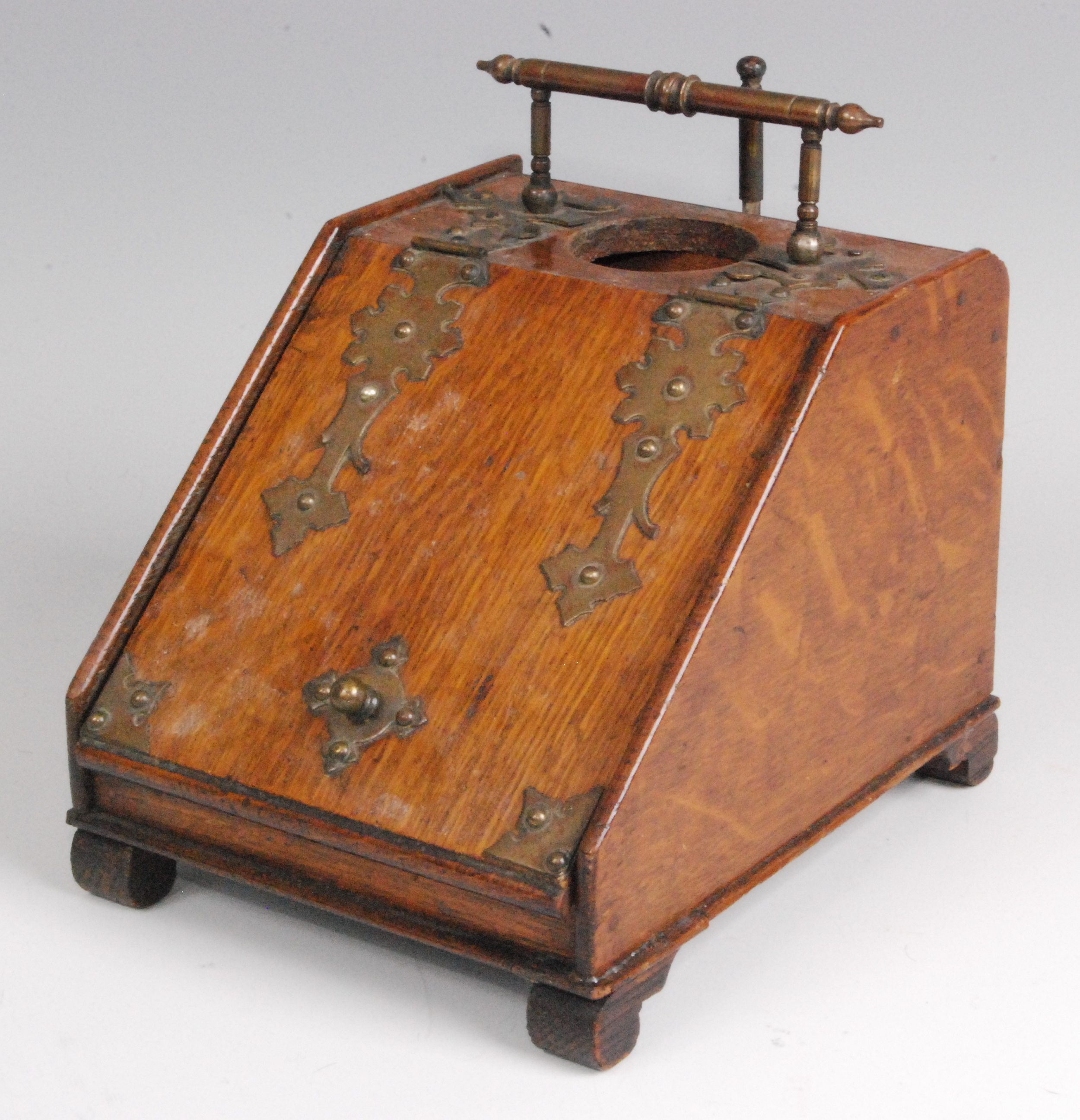 A late Victorian oak and brass mounted smokers companion, in the form of a coal-bin, the hinged