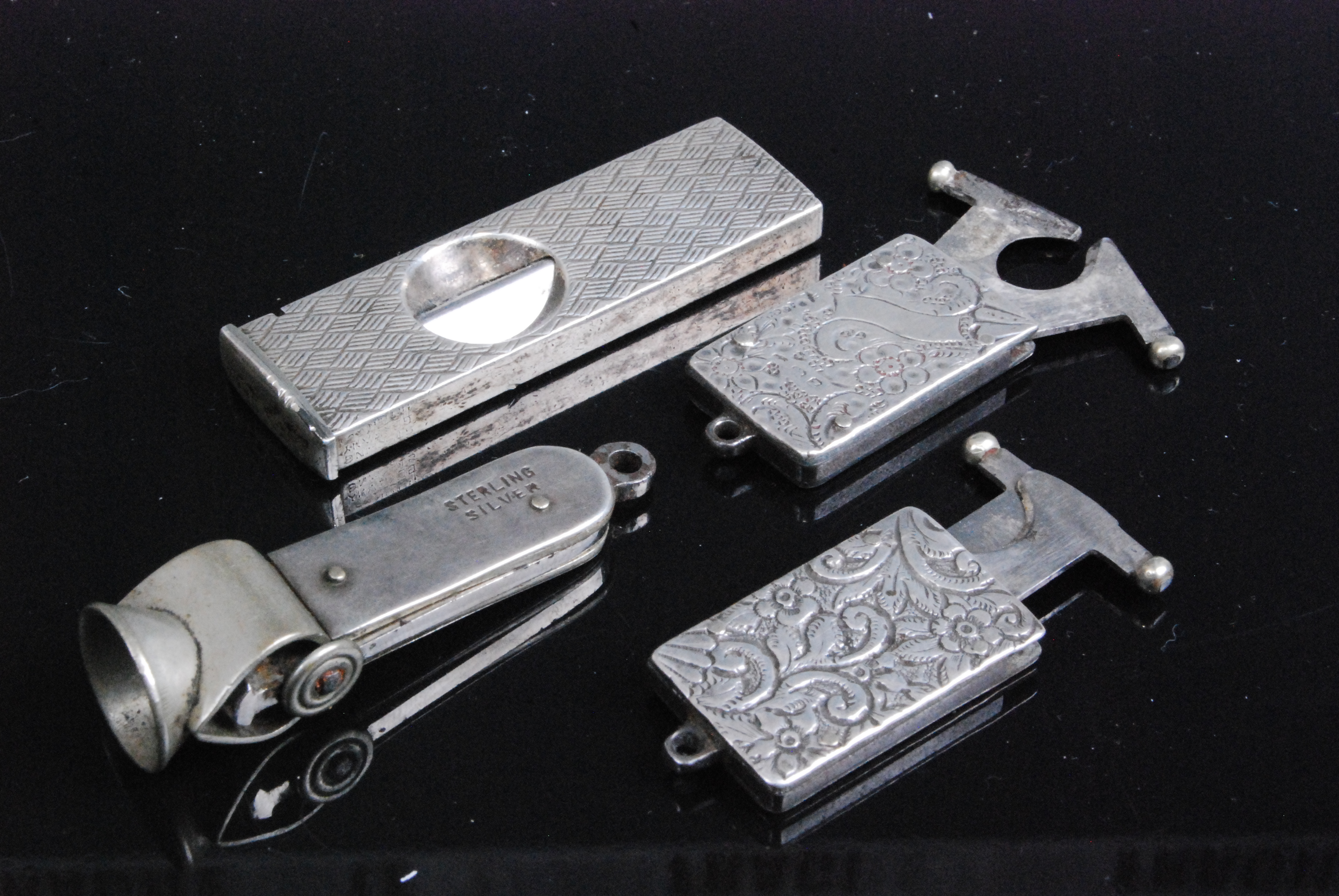 A late Victorian silver pocket cigar cutter of rectangular form having all over foliate engraved