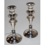 A pair of George V silver table candlesticks, each having a removable sconce on knopped stem and