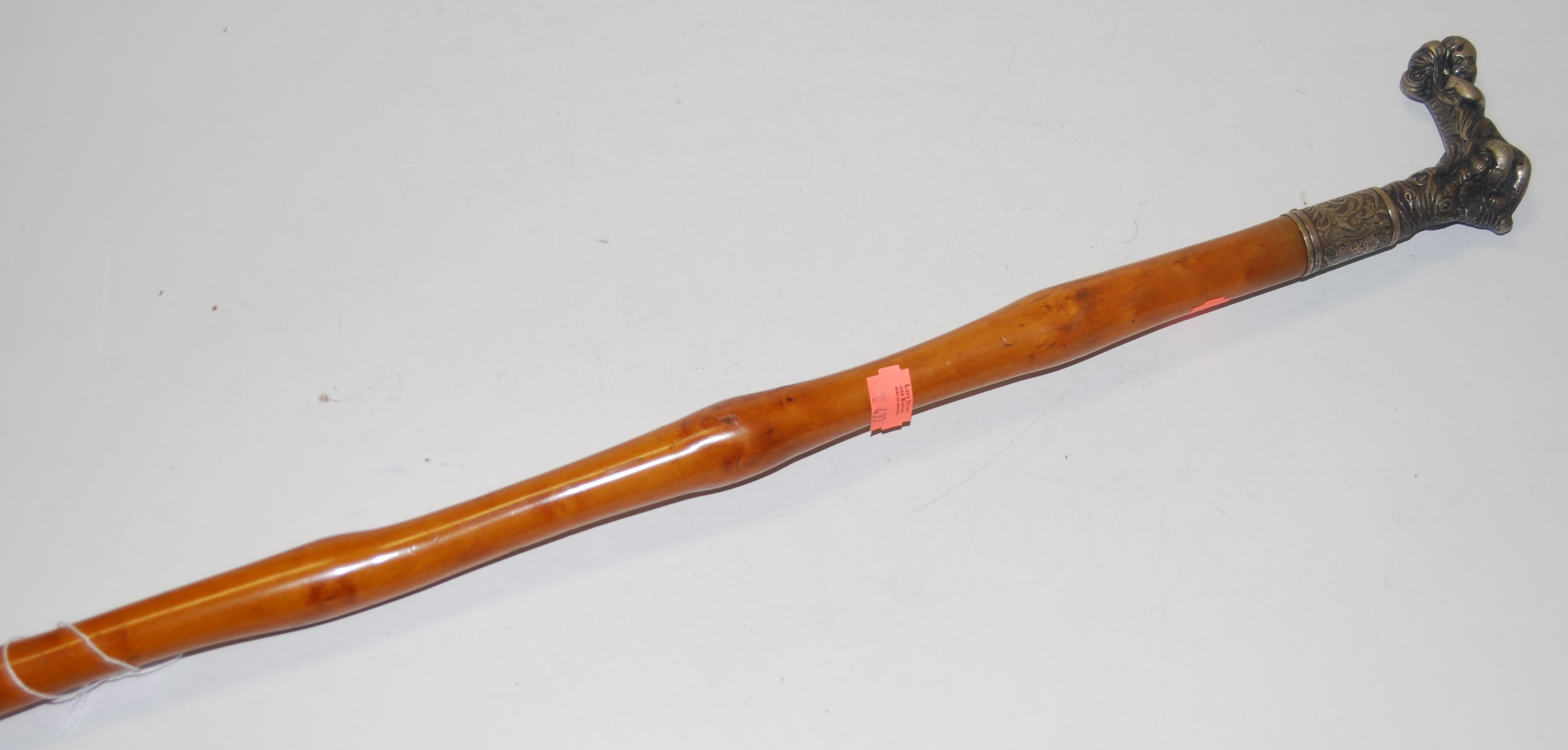 A circa 1900 walking cane, having a white metal collar, with probably associated figural handle