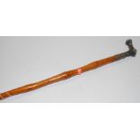A circa 1900 walking cane, having a white metal collar, with probably associated figural handle