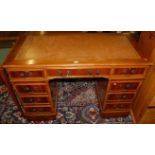 A reproduction yew wood and gilt tooled tan leather inset twin pedestal writing desk, w.120cm