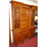 A Victorian oak dresser, having central three-tier open plate rack flanked by glazed cabinet