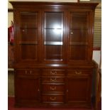 A contemporary cherry wood display cabinet having three bevelled glazed upper doors, interior