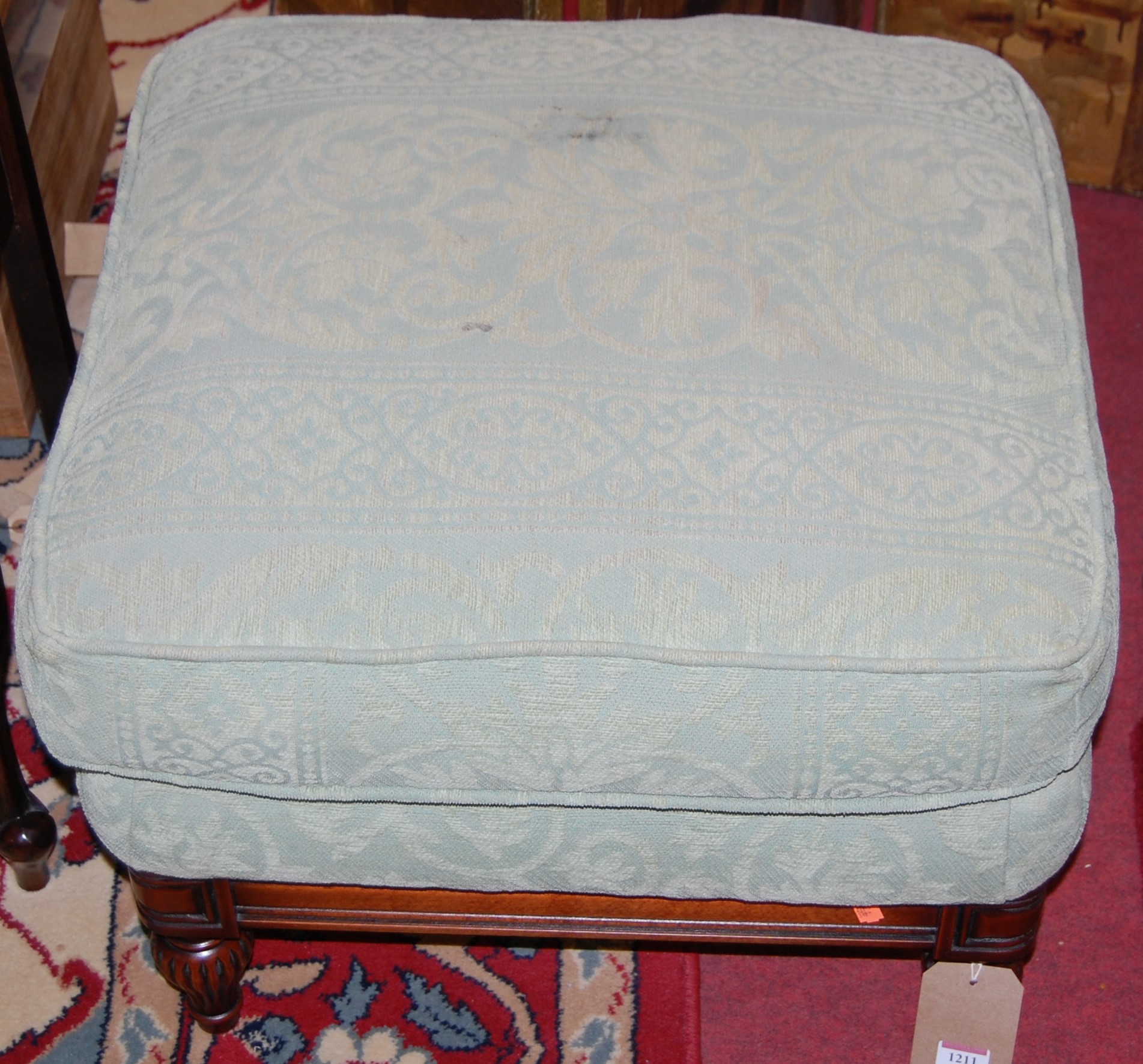 A contemporary green floral upholstered footstool