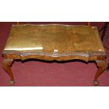 A figured walnut and crossbanded shaped top low coffee table, raised on acanthus leaf cabriole