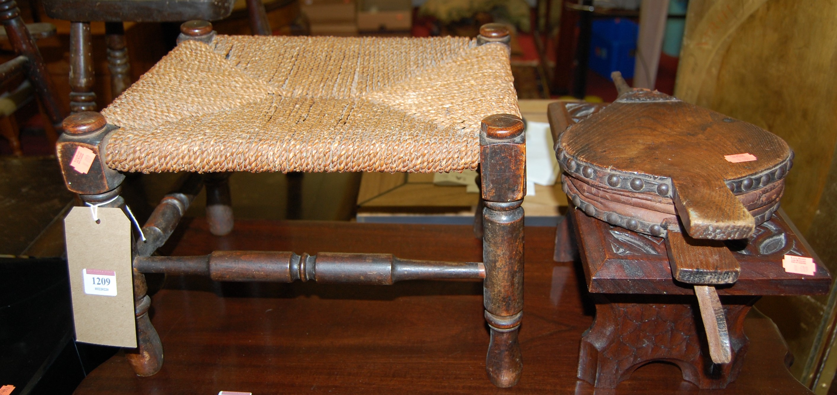 An early 20th century beech and rush low footstool, together with a carved walnut low footstool, and