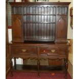 An early 20th century geometric moulded oak dresser, the open upper plate racks flanked by