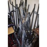 A collection of various contemporary tubular metal hanging clothes stands, mostly on roller castors