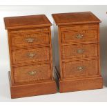 A pair of oak and burr oak three-drawer bedside chests, each having crossbanded tops and brushing