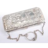 A late Victorian lady's silver evening purse, embossed to one side with an extensive landscape,