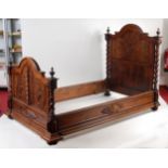 A pair of circa 1900 continental walnut single bedsteads, the panelled heads with raised and
