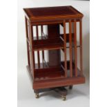 A good quality Sheraton style mahogany and inlaid revolving bookcase, having a four-quarter veneered