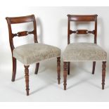 A pair of late Georgian mahogany barback dining chairs, each with leaf carved and reeded uprights,